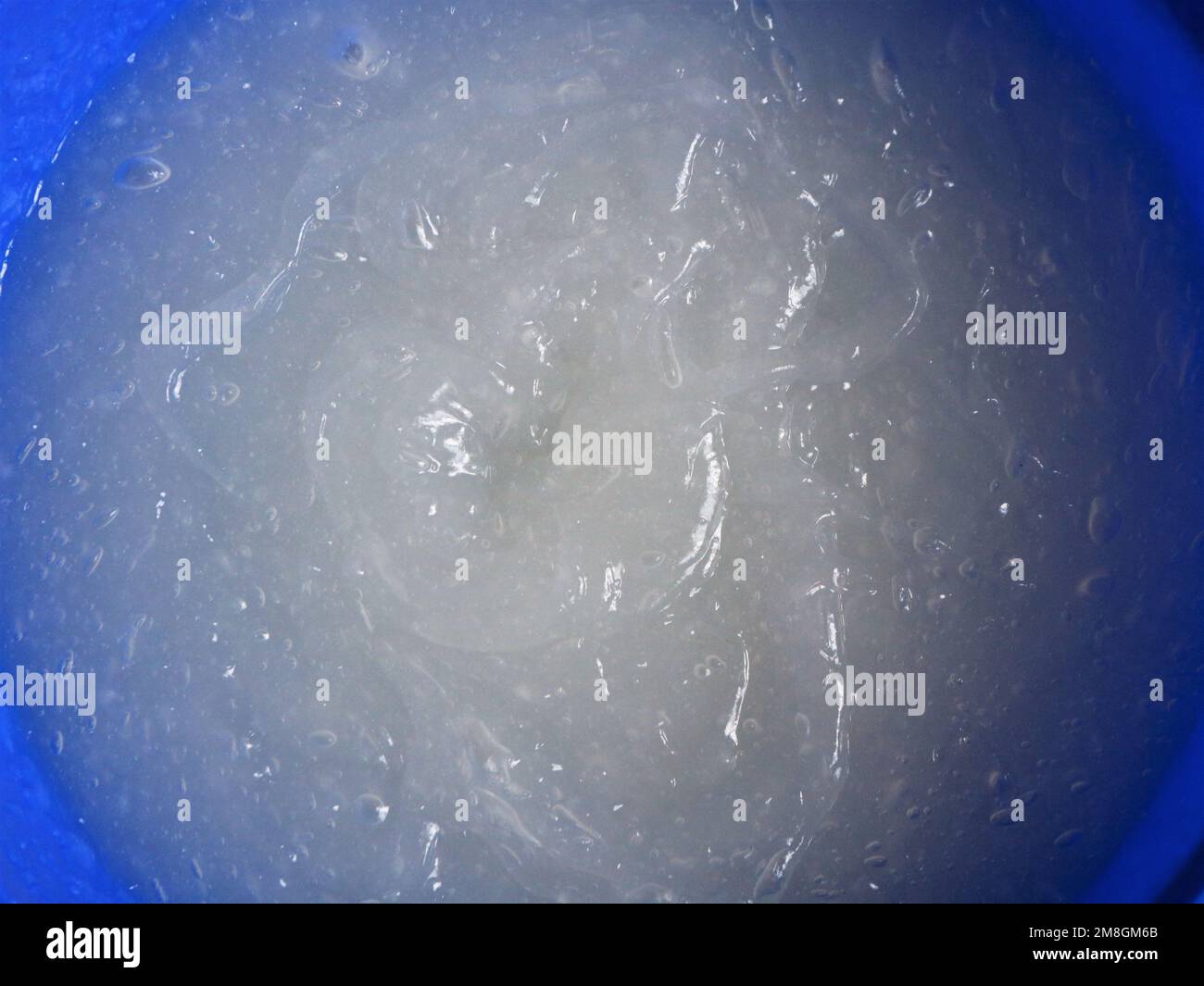 adhesive mixture in blue container top view closeup as texture