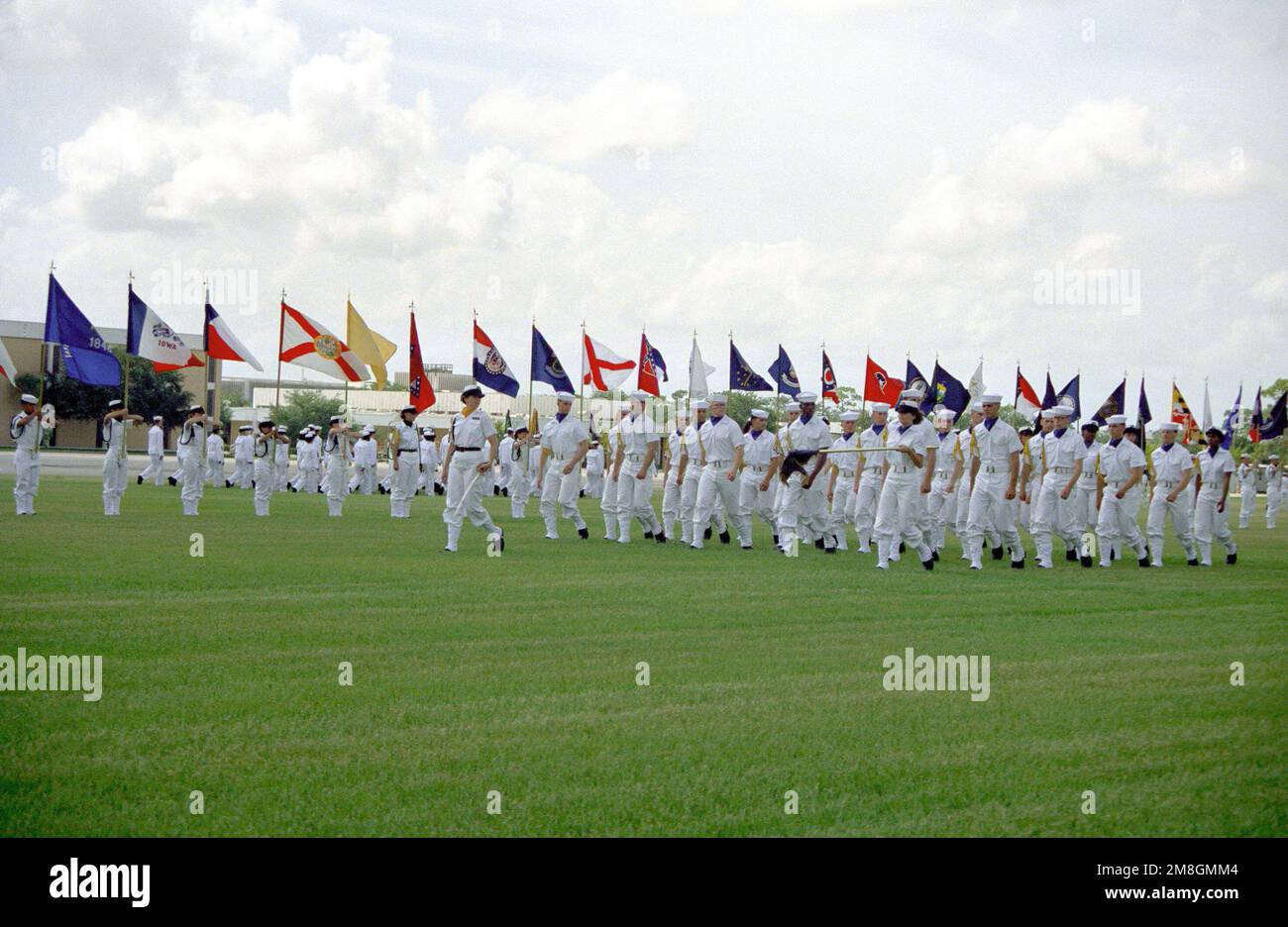 Members of a co-ed recruit company pass in review during their graduation ceremony. Recruit Training Command, Orlando, is the only Navy command where both men and women undergo basic training. Base: Naval Training Center, Orlando State: Florida(FL) Country: United States Of America (USA) Stock Photo