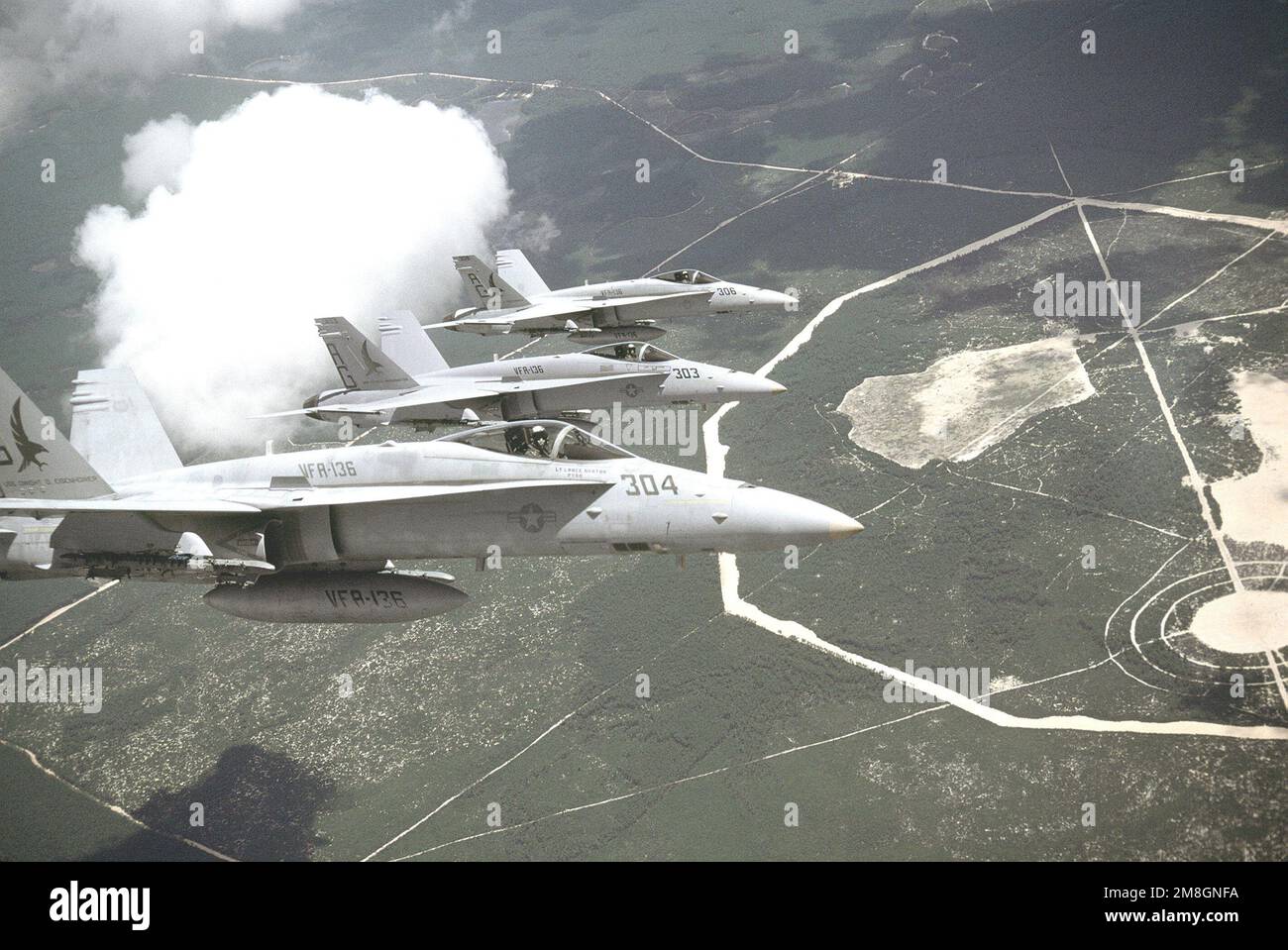 An air-to-air, right side view of three Strike Fighter Squadron 136 (VFA-136) F/A-18C Hornet aircraft flying in echelon. Country: Unknown Stock Photo