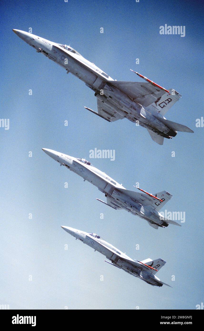 An air-to-air, left side view of three Strike Fighter Squadron 136 (VFA-136) F/A-18C Hornet aircraft flying in echelon. Country: Unknown Stock Photo