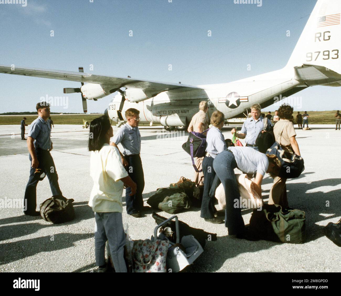U.S. Navy personnel collect their belongings after arriving at Andersen ...