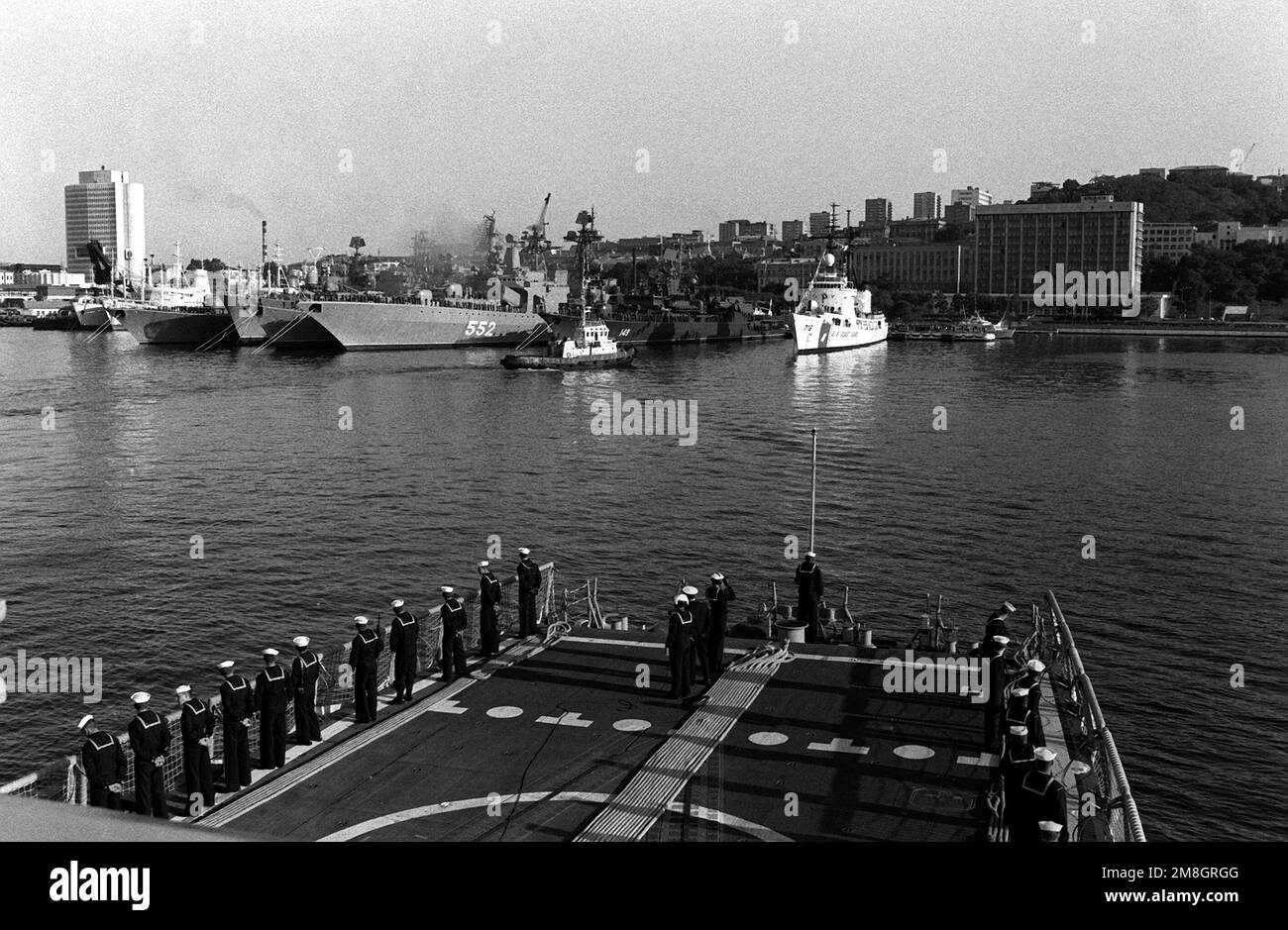 Crew members man the rail at the stern of the guided missile frigate