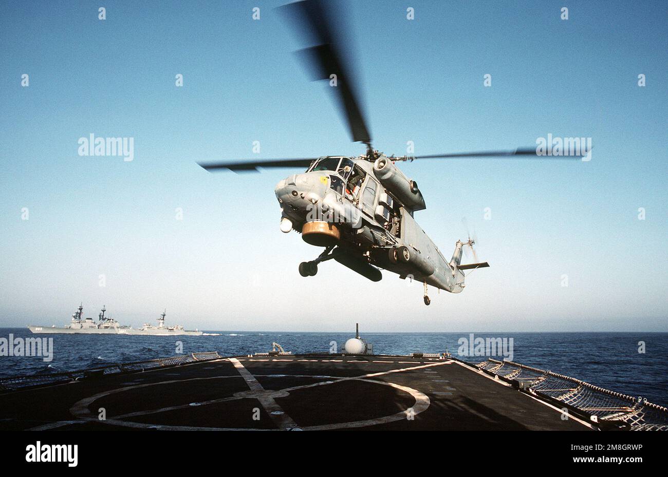 A Light Helicopter Anti-submarine Squadron 33 (HSL-33) SH-2F Sea Sprite helicopter lands on the flight deck of the frigate USS FANNING (FF-1076) during Exercise Eager Sentry 92-4. The destroyer USS KINDAID (DD-965) and the frigate USS KIRK (FF-1087) are in the background. Subject Operation/Series: EAGER SENTRY 92-4 Base: USS Fanning (FF 1076) Stock Photo