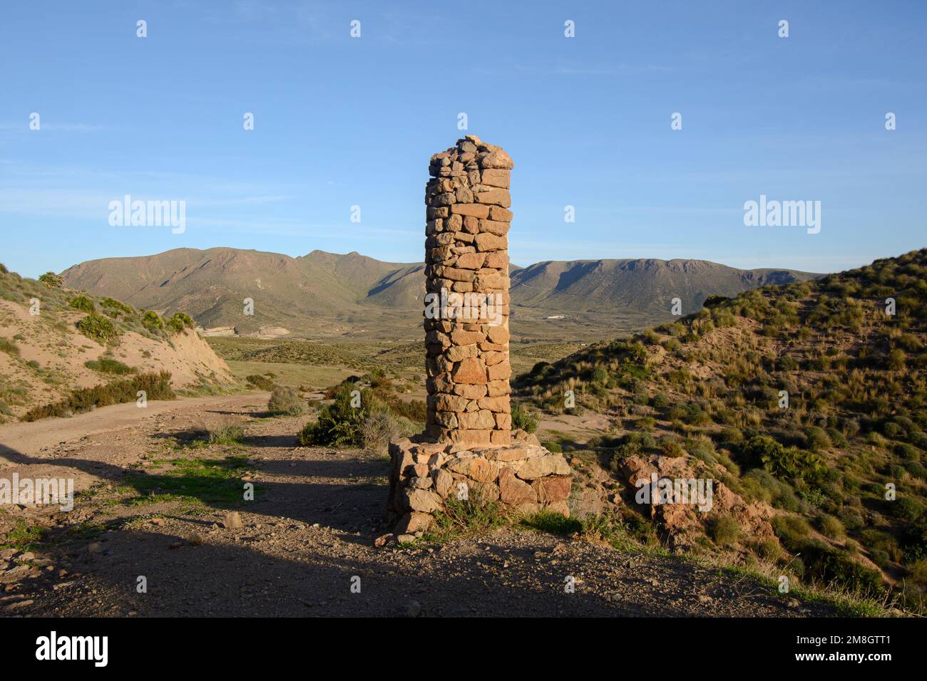 Obelisk on Cabo de Gata coastal path south of La Isleta del Moro, Almeria province, Spain. View from near El Embacadero. Stock Photo