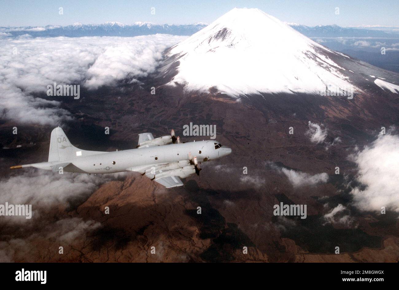 A high angle right-side view of a P-3 Orion aircraft in flight past Mount Fuji. The P-3 belongs to Patrol Squadron 22 from Moffett Field, Calif., on temporary duty in Japan. Country: Japan (JPN) Stock Photo