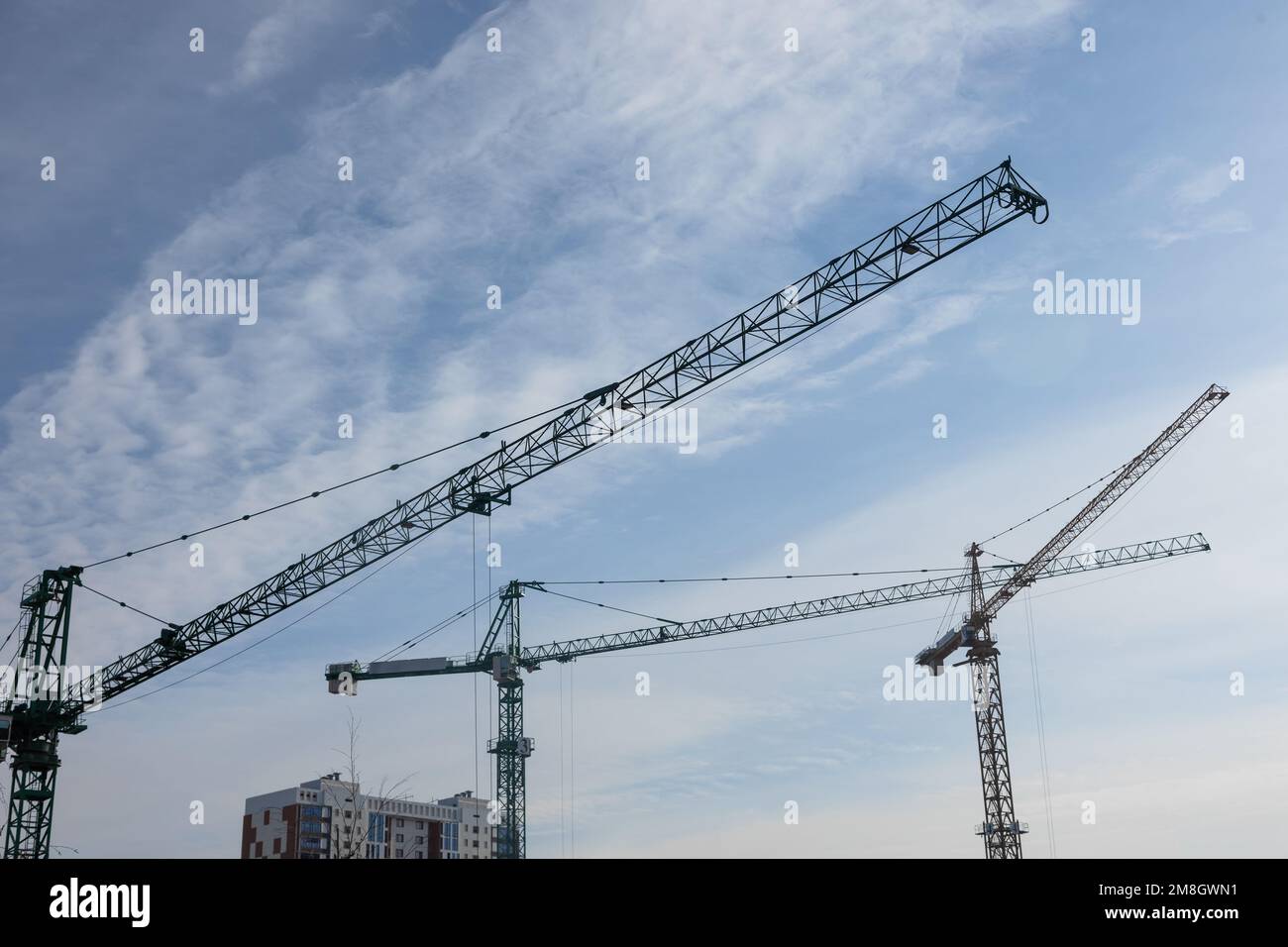 Construction cranes against the blue sky Stock Photo