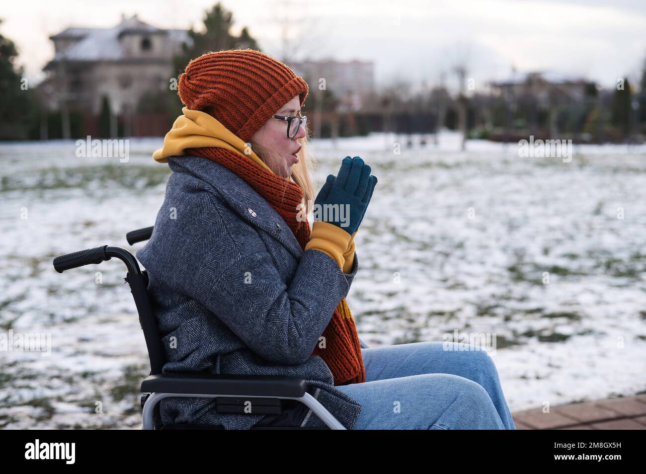 Caucasian woman freezes in a wheelchair in winter. Stock Photo