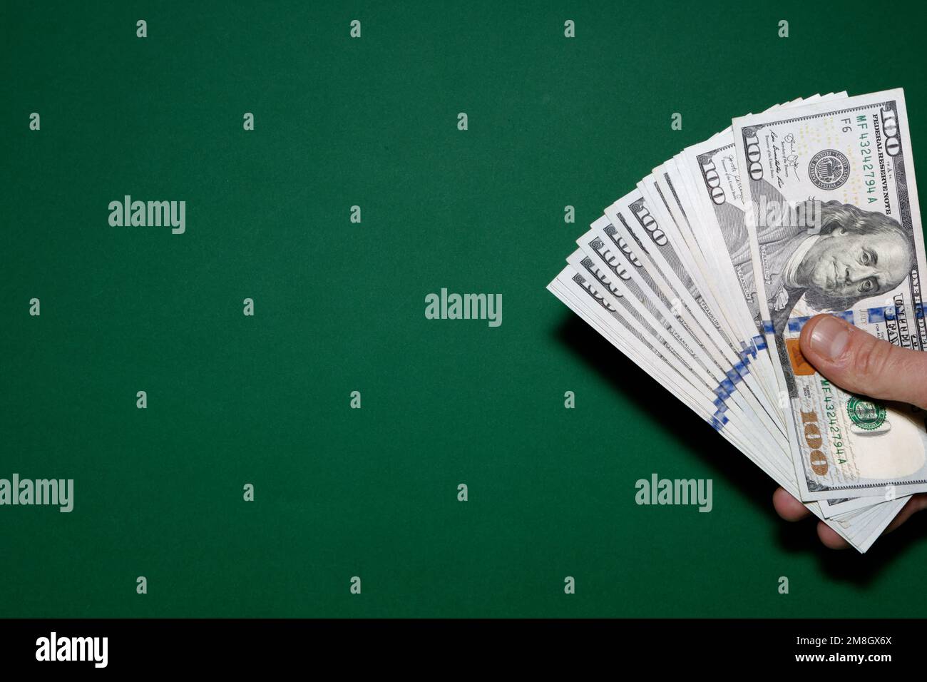 100 dollar bill holds in hand on green background 100 dollar bill