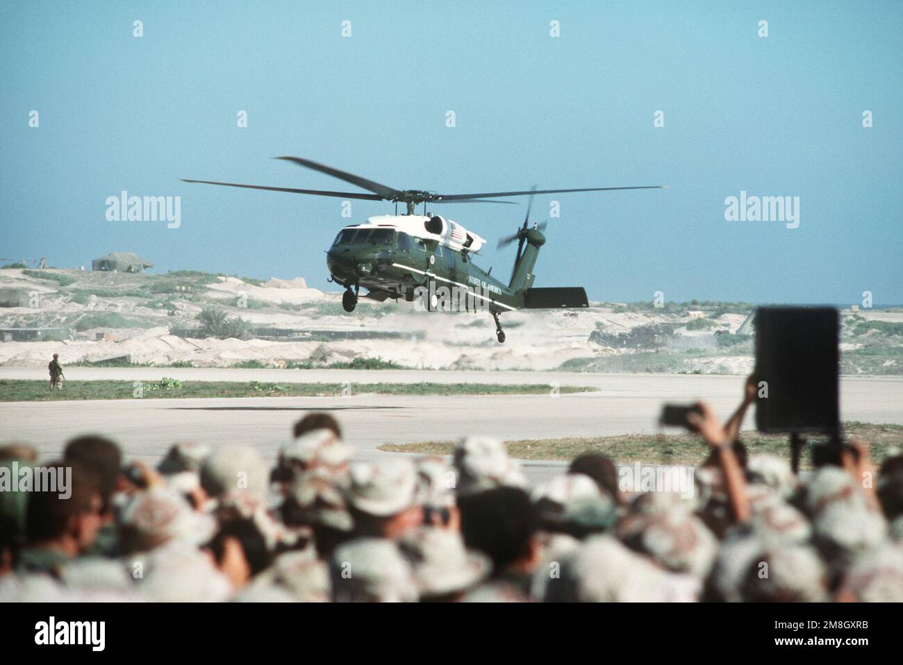 A UH-60 Black Hawk (Blackhawk) helicopter prepares to touch down bringing President George Bush to visit the troops at the airport. Subject Operation/Series: RESTORE HOPE Base: Mogadishu Country: Somalia (SOM) Stock Photo