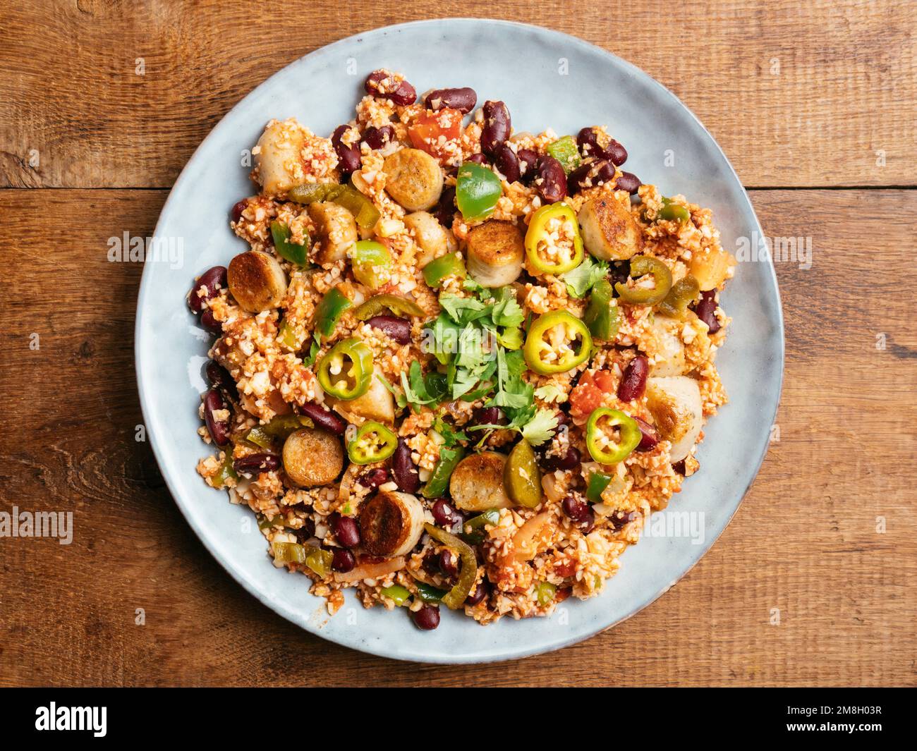 Plate with a cauliflower rice Jambalaya with vegan sausages. Stock Photo
