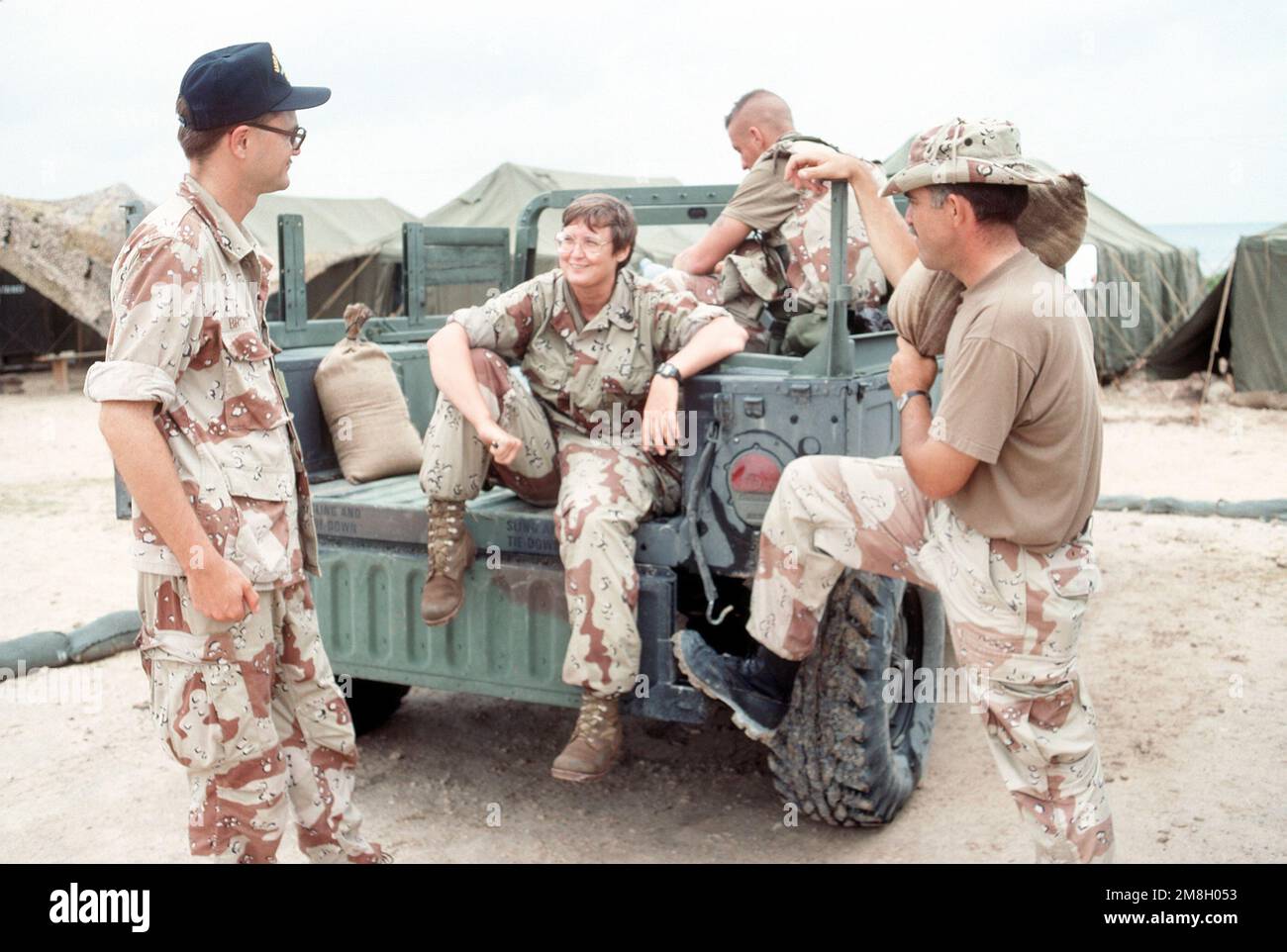 Members of the Joint Information Bureau relax around an M998 series