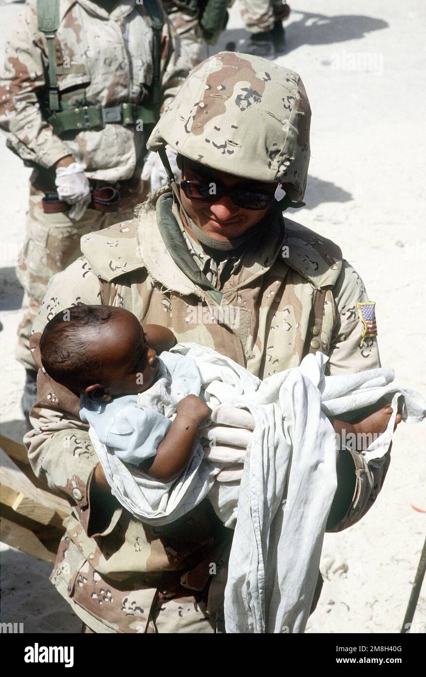 A Navy Corpsman, assigned to Combat Service Support Detachment 15 (CSSD-15), examines a Somali infant. He is participating in a medical civic action program during the multinational relief effort Operation Restore Hope. Subject Operation/Series: RESTORE HOPE Base: Mogadishu Country: Somalia (SOM) Stock Photo