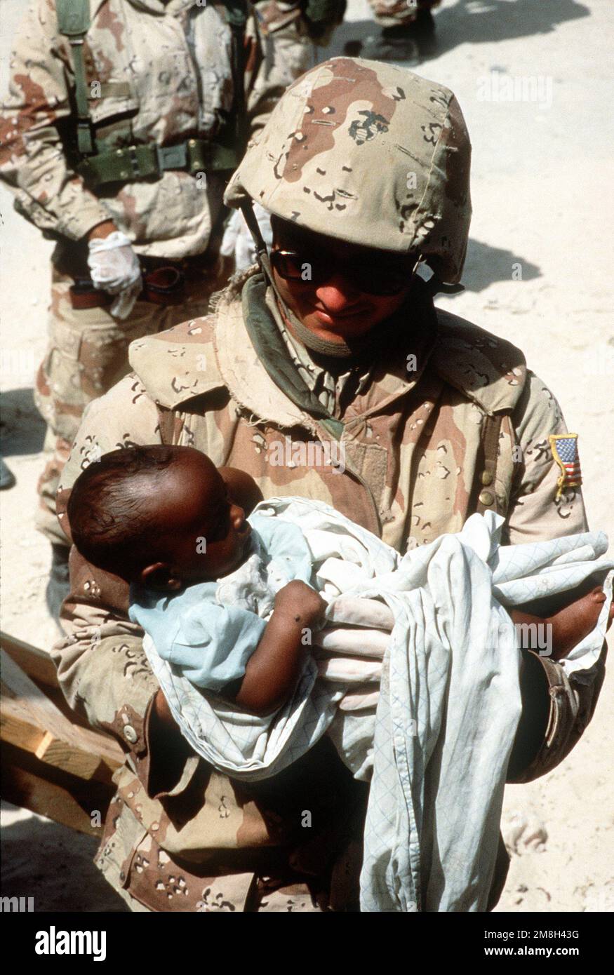 A Navy corpsman, assigned to Combat Service Support Detachment 15 (CSSD-15), examines a Somali infant while participating in a medical civic action program during the multinational relief effort Operation Restore Hope. Subject Operation/Series: RESTORE HOPE Base: Mogadishu Country: Somalia (SOM) Stock Photo