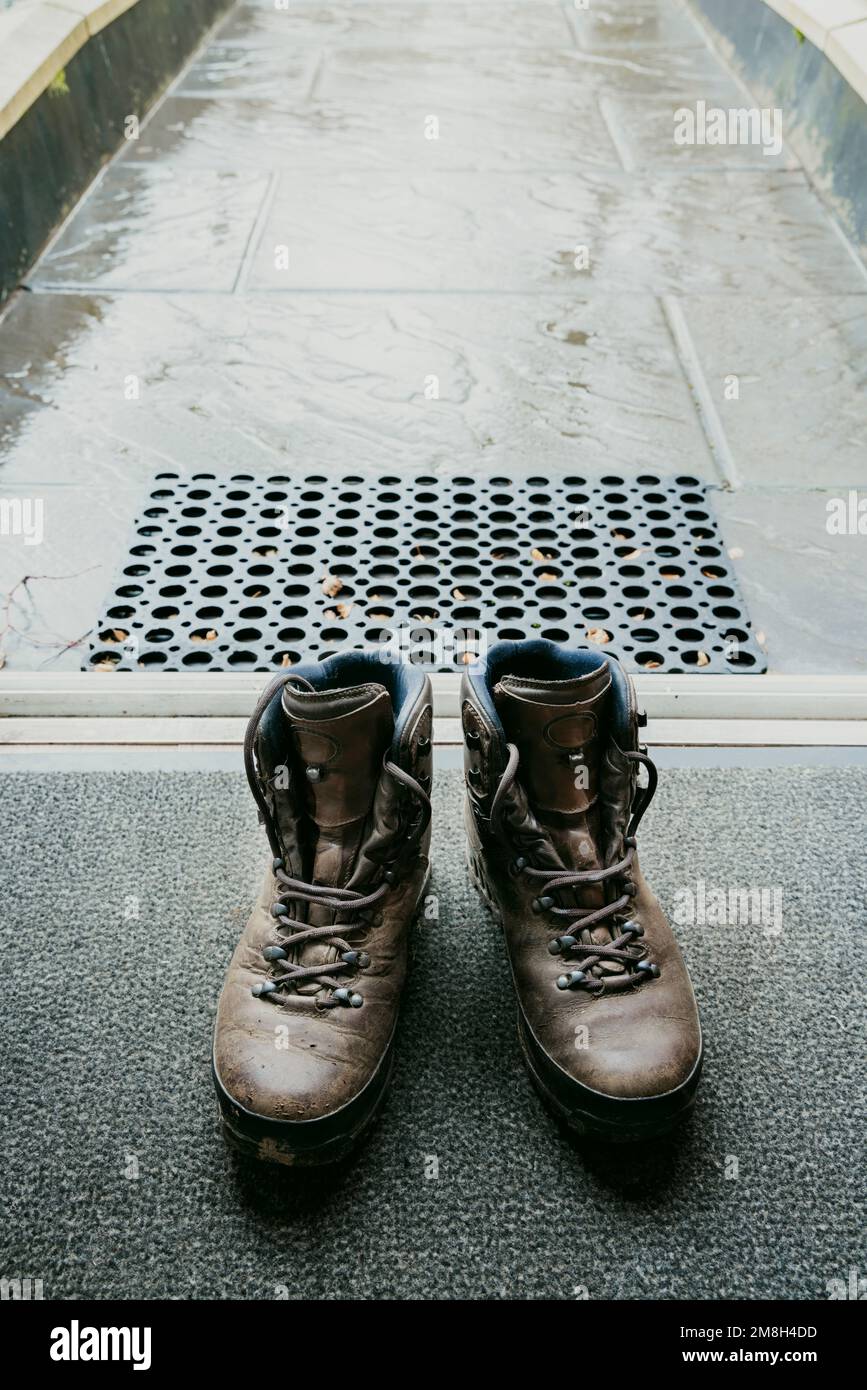 Leather walking boots on a door mat Stock Photo Alamy