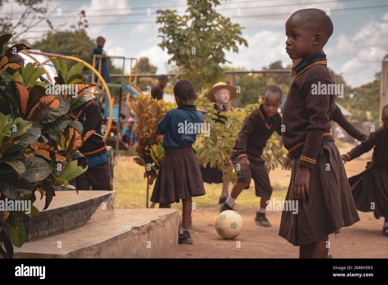 25th of March 2022 - Mwanza, Tanzania - Children playing in their school grounds and having fun. Running, skipping rope, playing football. Stock Photo