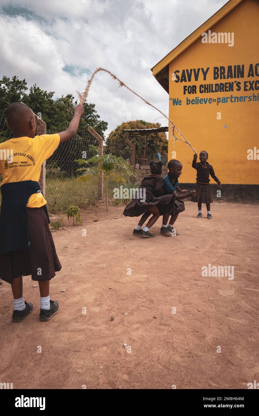 25th of March 2022 - Mwanza, Tanzania - Children playing in their school grounds and having fun. Running, skipping rope, playing football. Stock Photo