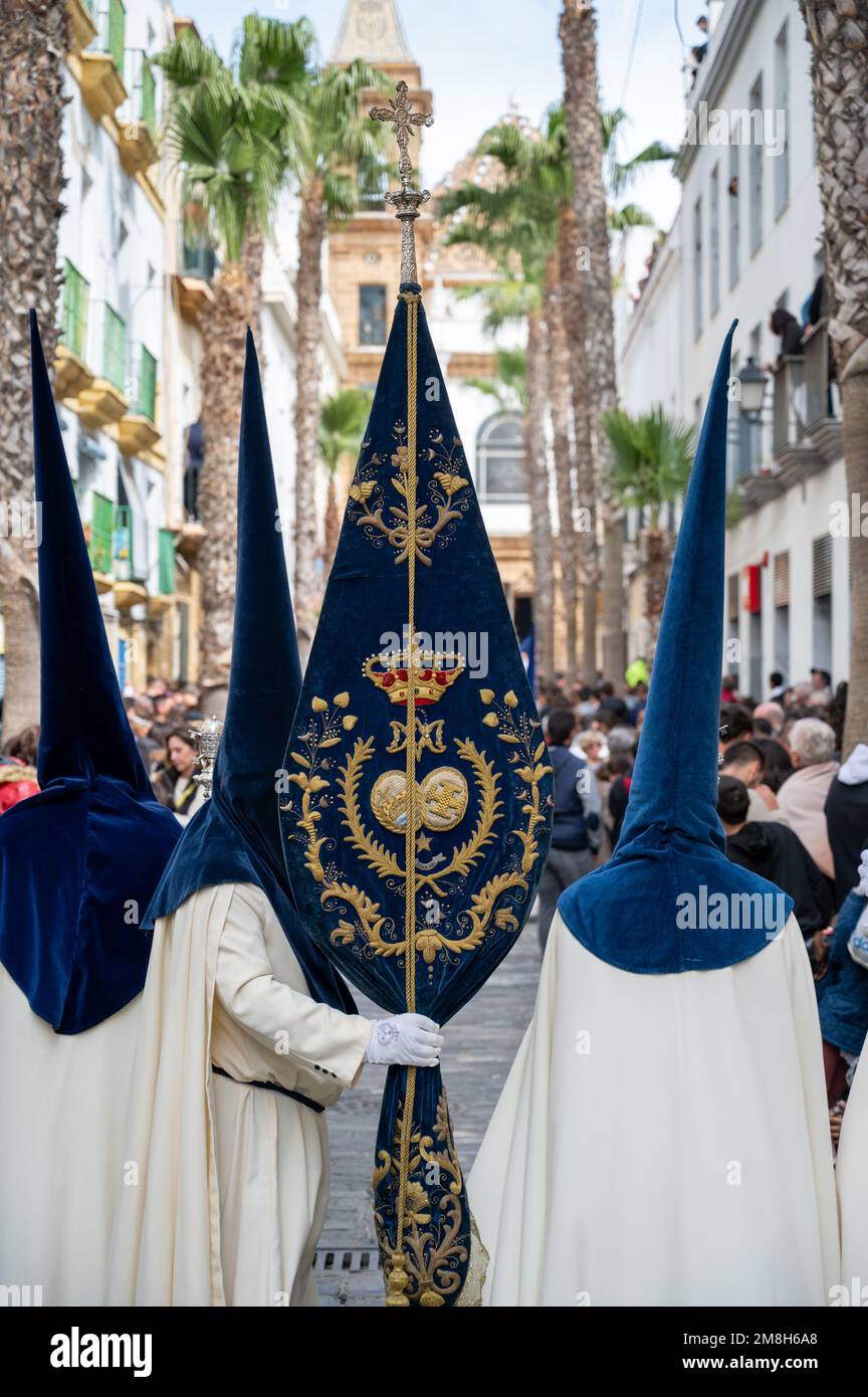 People in traditional dress weraing a capriote, or pointed hat in an Easter Parade during Holy Week or Semana Santa in Cadiz, Spain Stock Photo