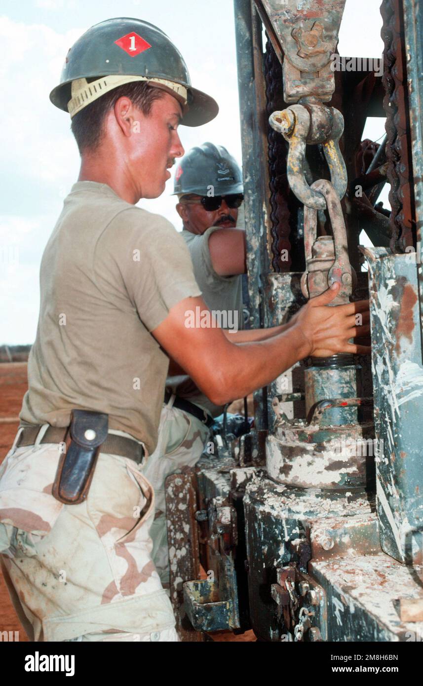 A member of Naval Mobile Construction Battalion 1 (NMCB-1) works on a rig drilling a water well during the multinational relief effort Operation Restore Hope. The well, near Bale Dogle is intended to supply an old Soviet air base being used by U.S. and Moroccan personnel participating in the operation. Subject Operation/Series: RESTORE HOPE Country: Somalia (SOM) Stock Photo