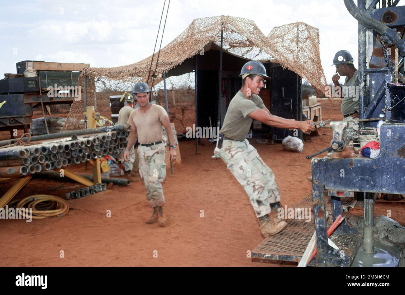 Members of Naval Mobile Construction Battalion 1 (NMCB-1) work on a rig drilling a water well during the multinational relief effort Operation Restore Hope. The well, near Bale Dogle, is intended to supply an old Soviet air base being used by U.S. and Moroccan personnel participating in the operation. Subject Operation/Series: RESTORE HOPE Country: Somalia (SOM) Stock Photo