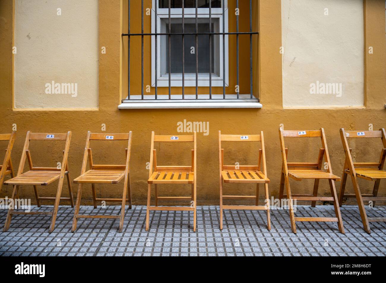 Chairs ready for spectators at an Easter Parade in Holy week at Easter or Semana Santa  in Cadiz Spain Stock Photo