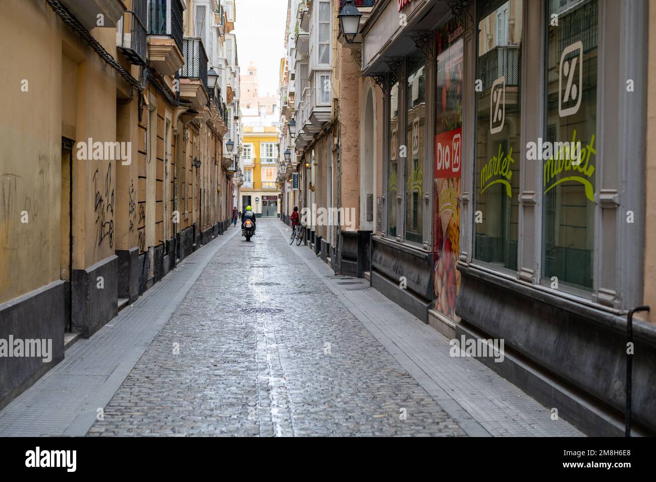 A narrow street in the city of Cadiz Spain with cobbles and shops Stock Photo