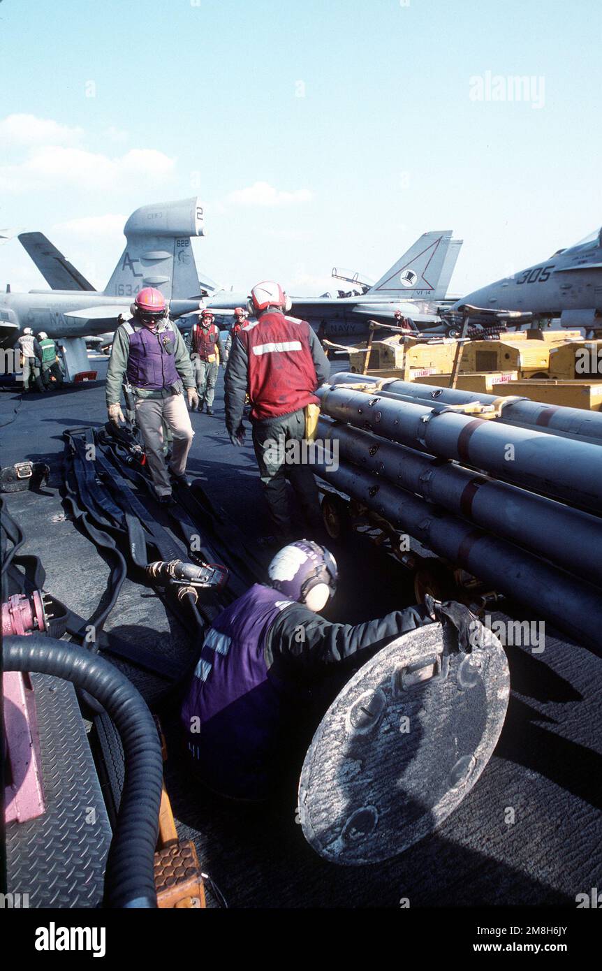 Aviation ordnancemen and fuel handlers prepare to service aircraft on the flight deck of the aircraft carrier USS JOHN F. KENNEDY (CV-67). Country: Adriatic Sea Stock Photo
