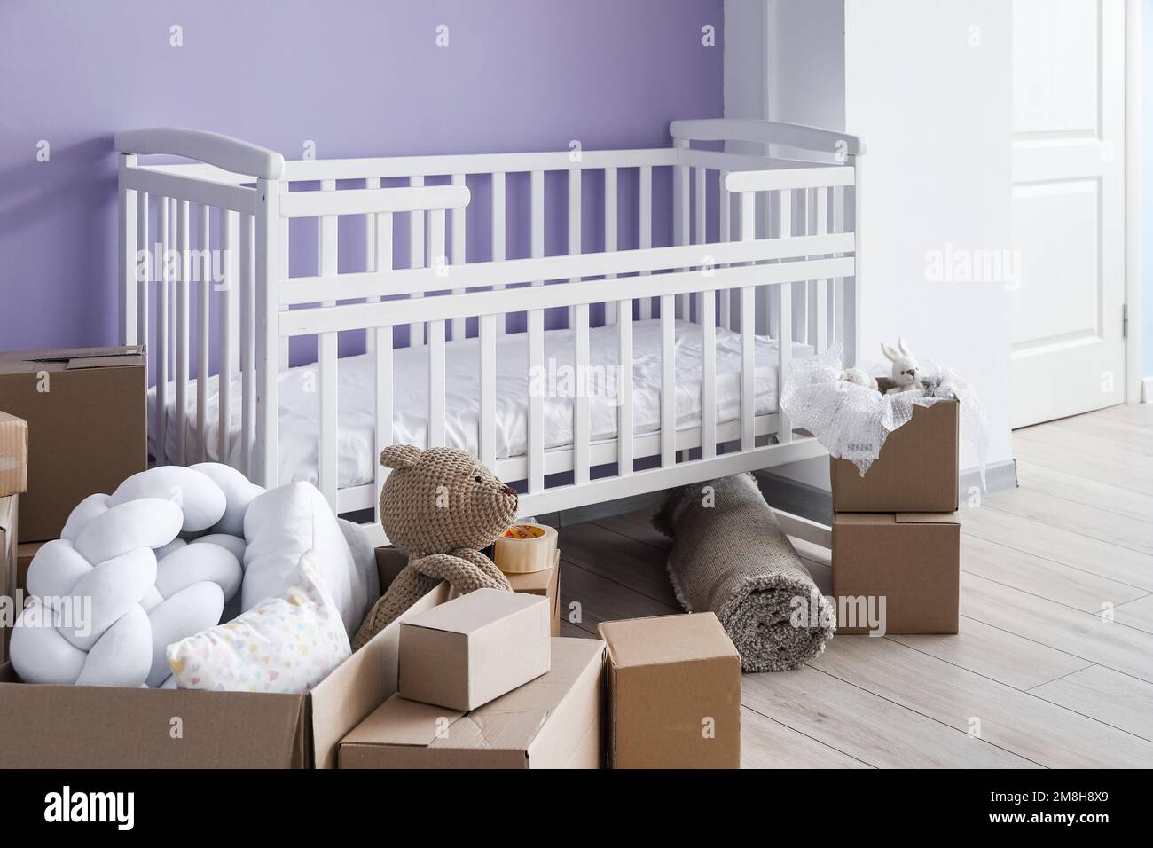 Cardboard boxes with baby crib in children s bedroom on moving day