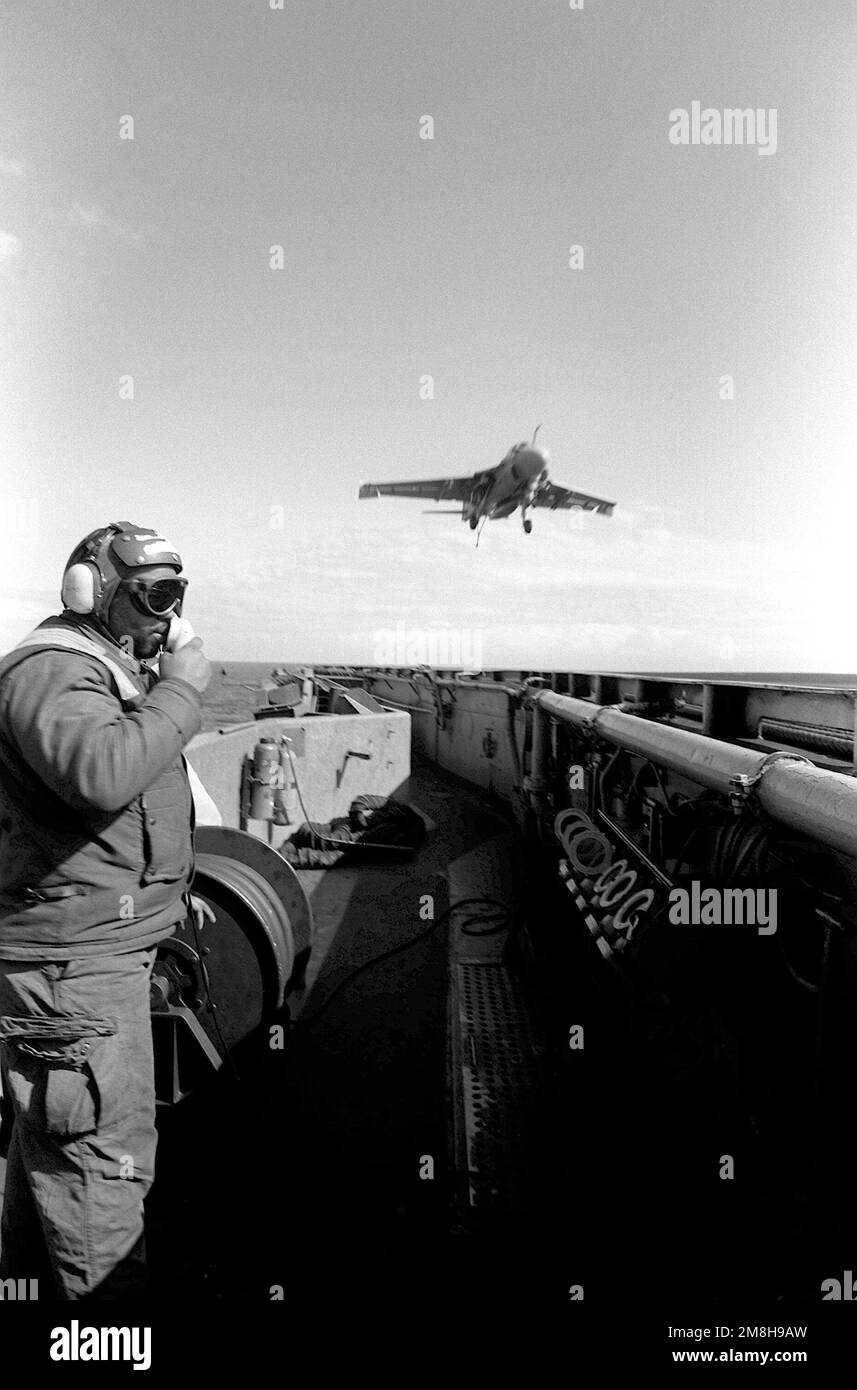 A flight deck crew member watches as an Attack Squadron 75 (VA-75) A-6E Intruder aircraft prepares to touch down on the flight deck of the aircraft carrier USS JOHN F. KENNEDY (CV-67) during flight operations aboard the vessel. Country: Adriatic Sea Stock Photo