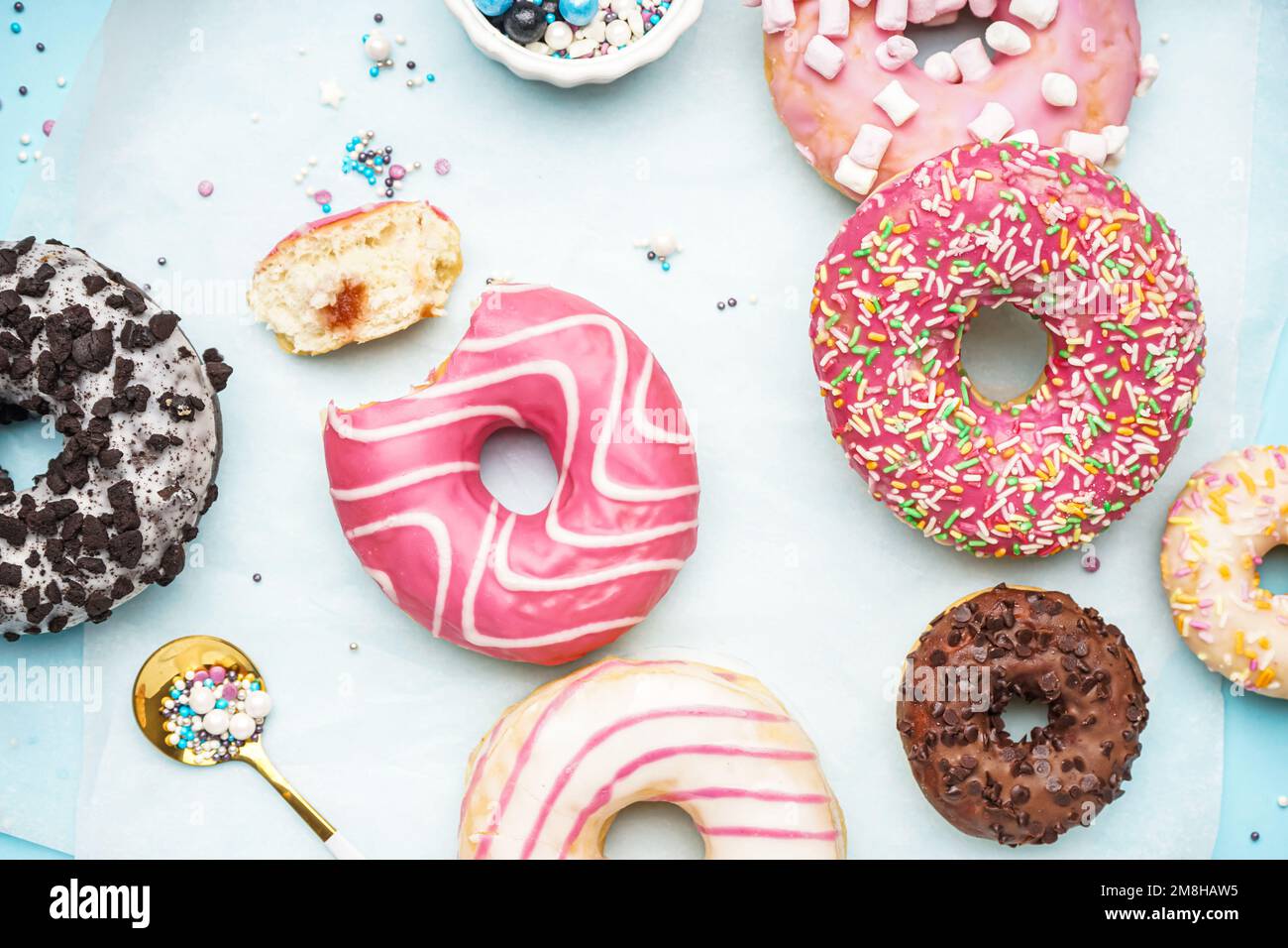 Parchment with different delicious donuts on blue background Stock Photo