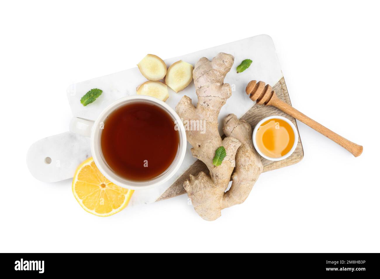 Board with ginger root, cup of black tea, honey and lemon isolated on