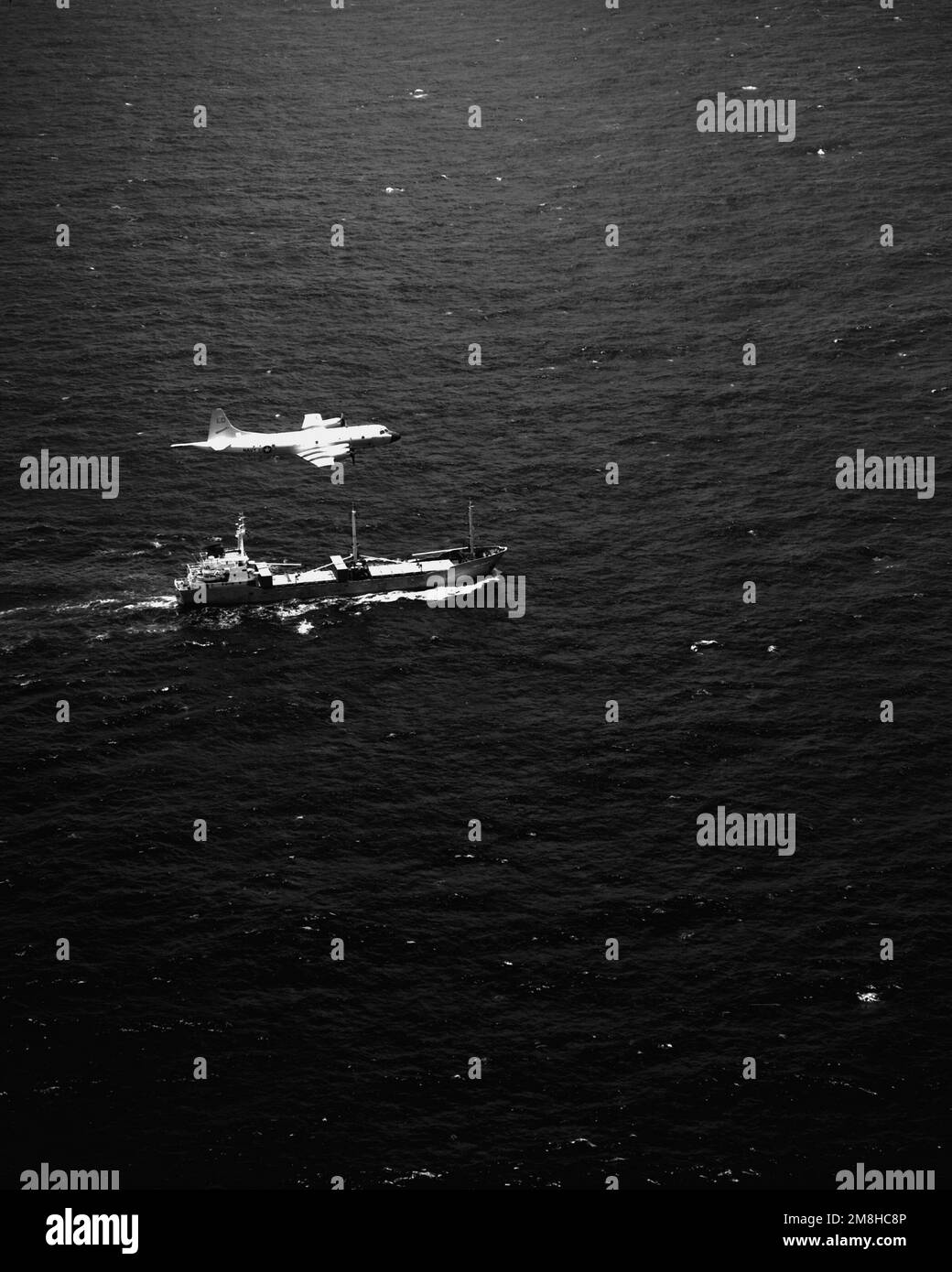 A P-3C Orion aircraft of Patrol Squadron 10 (VP-10) flies over the SS Sea Chariot, a merchant vessel suspected of drug-trafficking activities. Discovered by the patrol squadron's Combat Aircrew Two in the waters southwest of Costa Rica, the ship was found to be carrying II,233 pounds of cocaine when boarded by U.S. Coast Guard personnel. Country: Pacific Ocean (POC) Stock Photo