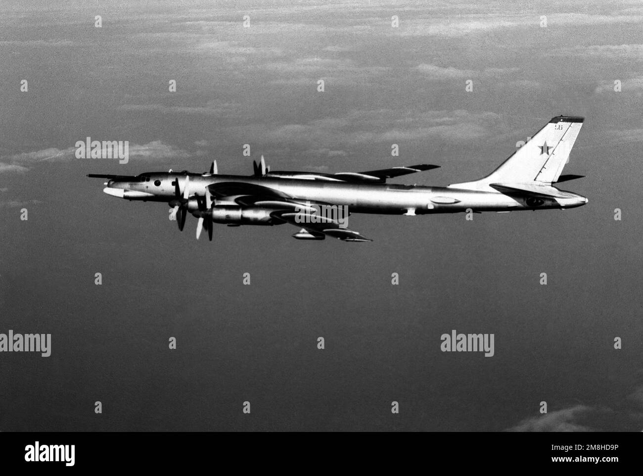 An air-to-air left side view of a Russian Tu-95 Bear G bomber aircraft over the Western Pacific. Country: Unknown Stock Photo