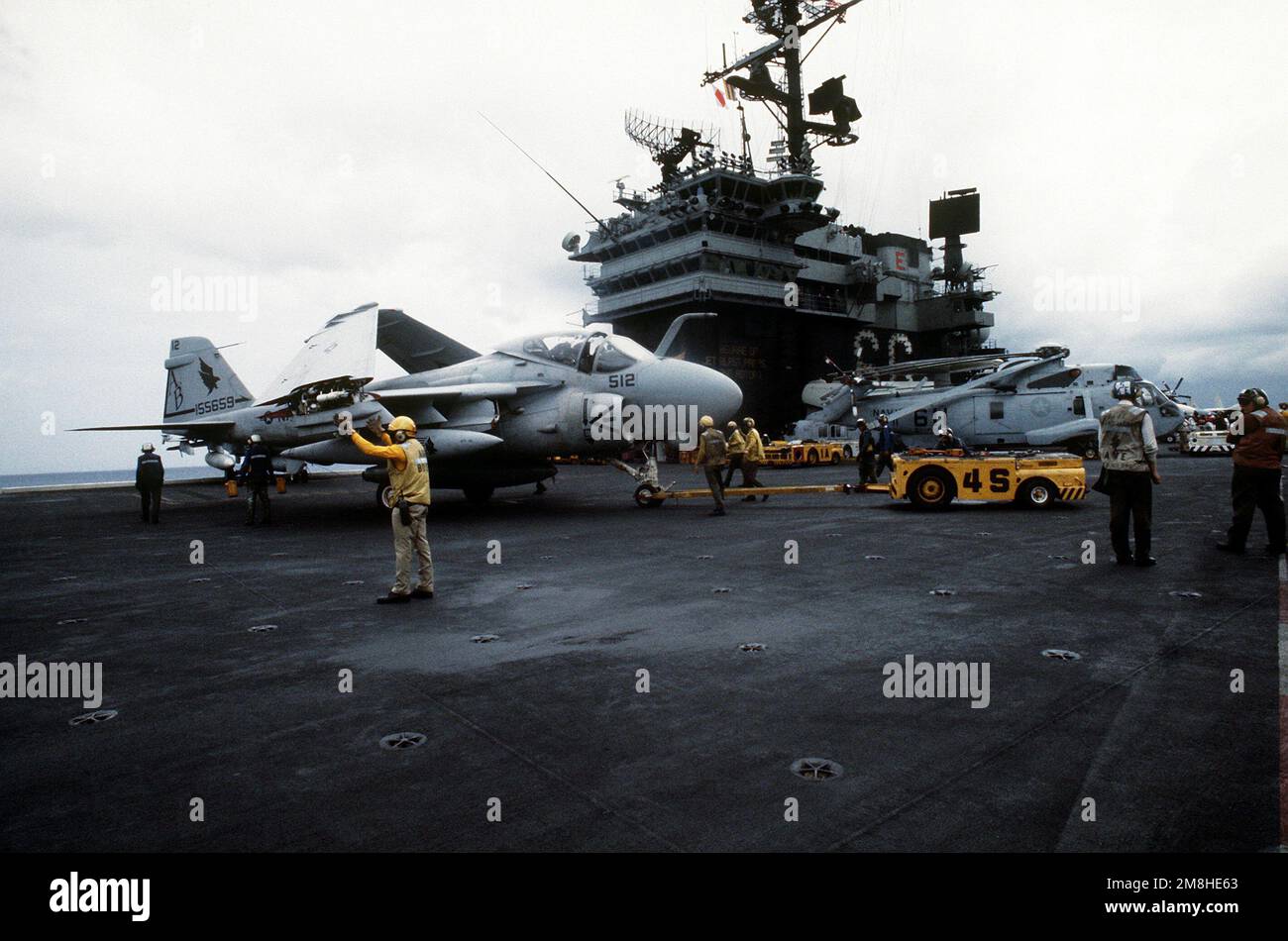 Flight deck crewmen use an MD-3A tow tractor to position an A-6E ...