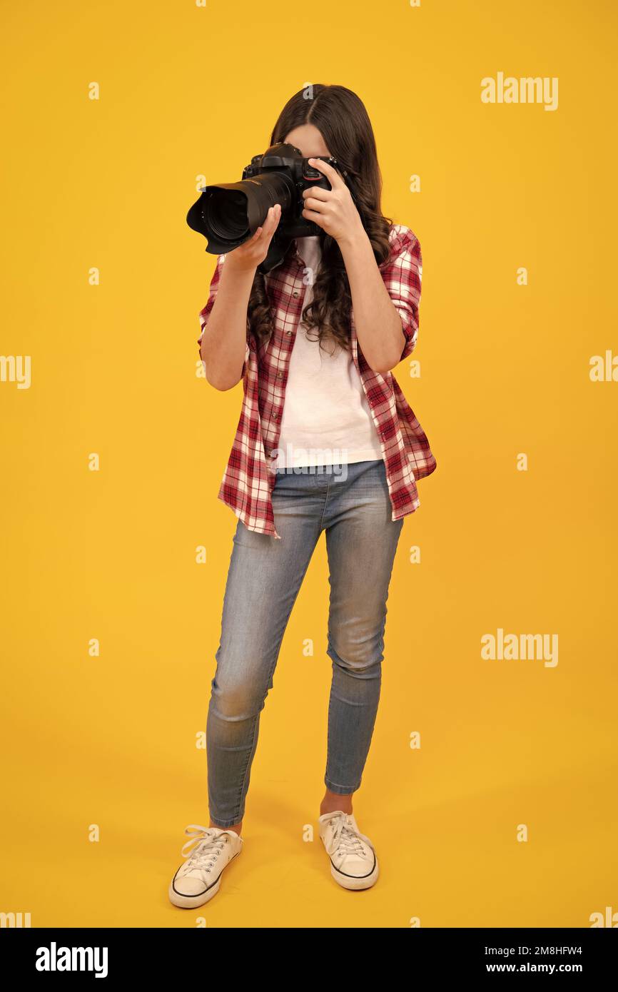 Teenager girl photographer with a dslr camera. Kid use digital camera. Child photographing. School of photography. Kid photographer beginner. Stock Photo