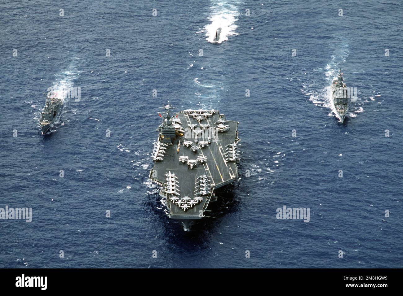 A high oblique bow-on view of WestPac '93 Battle Group Foxtrot underway. (Left to right). The guided missile frigate USS INGRAHAM (FFG-61), the nuclear-powered attack submarine USS PASADENA (SSN-752), the nuclear-powered aircraft USS ABRAHAM LINCOLN (CVN-72), and the guided missile cruiser USS FOX (CG-33). Country: Pacific Ocean (POC) Stock Photo