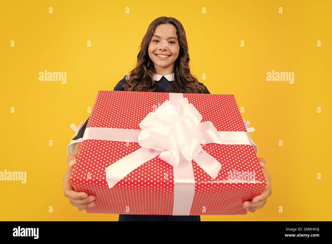 Portrait of a teenager child girl holding present box isolated over ...
