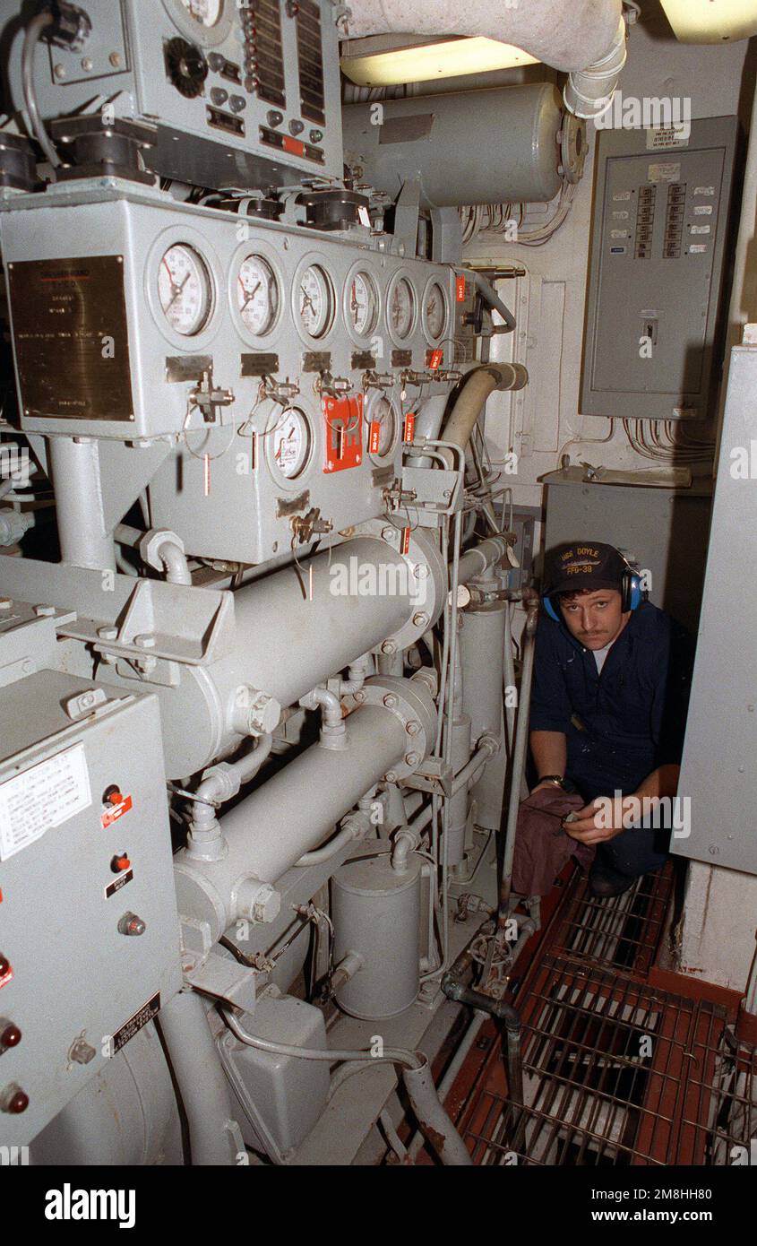 A crewman works in an engineering space aboard the guided missile ...