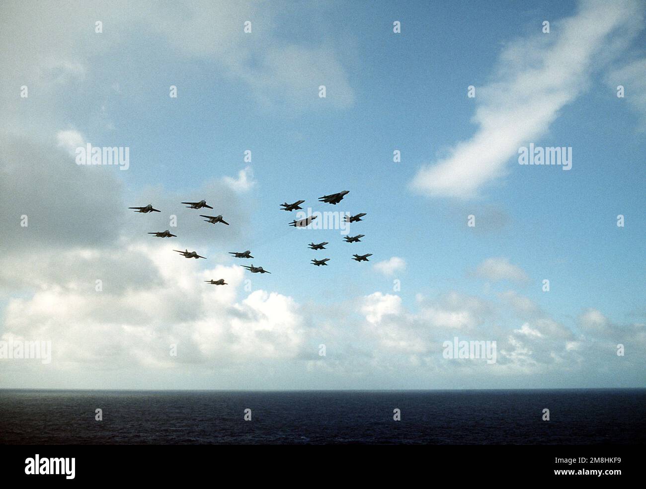 A view of a formation of aircraft assigned to Carrier Wing Eleven (CVW-11) during a fly-by past the nuclear-powered aircraft carrier USS ABRAHAM LINCOLN (CVN-72) as part of a fire power demonstration. The units involved are Attack Squadron 95 (VA-95). Tactical Electronic Warfare Squadron 135 (VAQ-135), Fighter Squadron (VF-213), Strike Fighter Squadron 22 (VFA-22), Strike Fighter Squadron 94 (VFA-94), Marine Strike Fighter Squadron 314 (VMFA-314) and Air Anti-Submarine Squadron 29 (VS-29). Country: Western Pacific Stock Photo