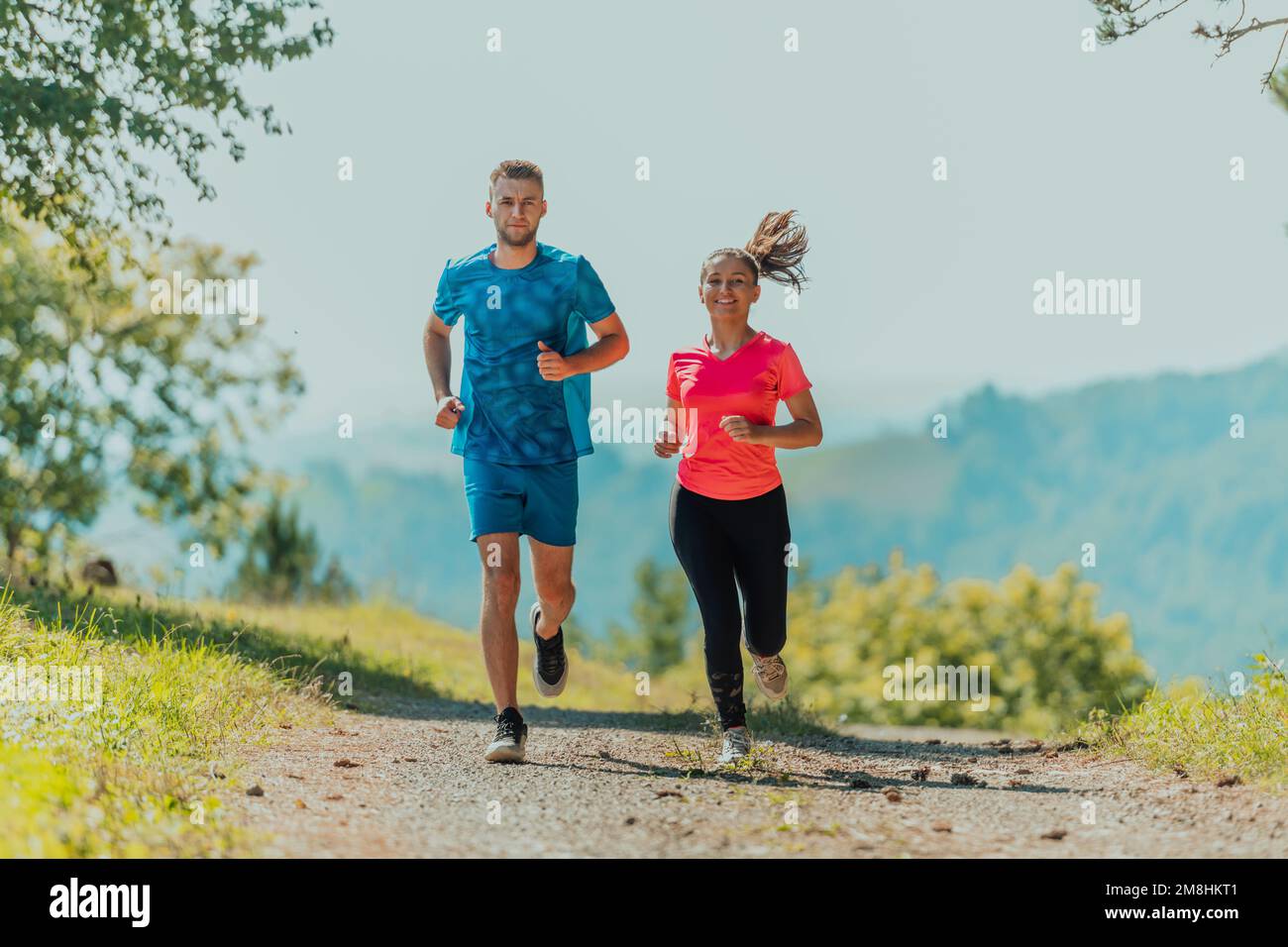 woman jogging on a country road through the beautiful sunny forest,  exercise and fitness concept Stock Photo - Alamy
