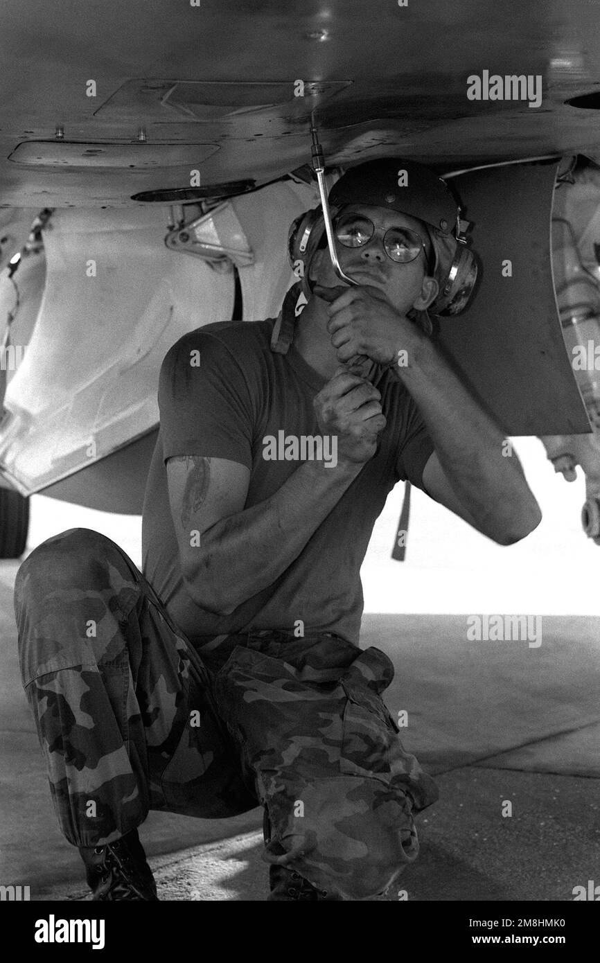 SGT. Michael L. Carter, a Marine aircraft mechanic from VMFA115 at work under the fuselage of