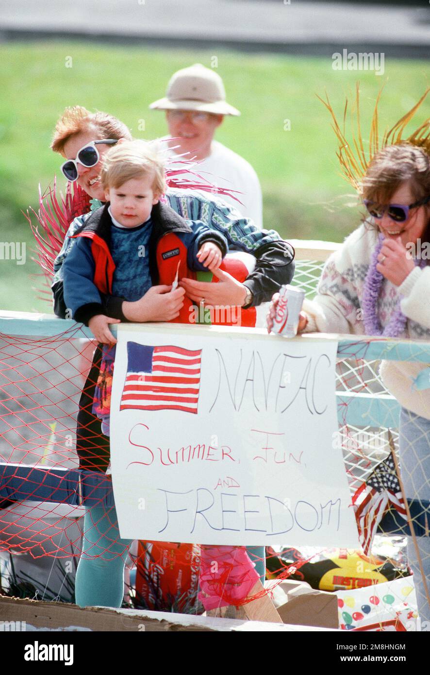 Military dependents ride on a parade float representing the U.S. Navy ...