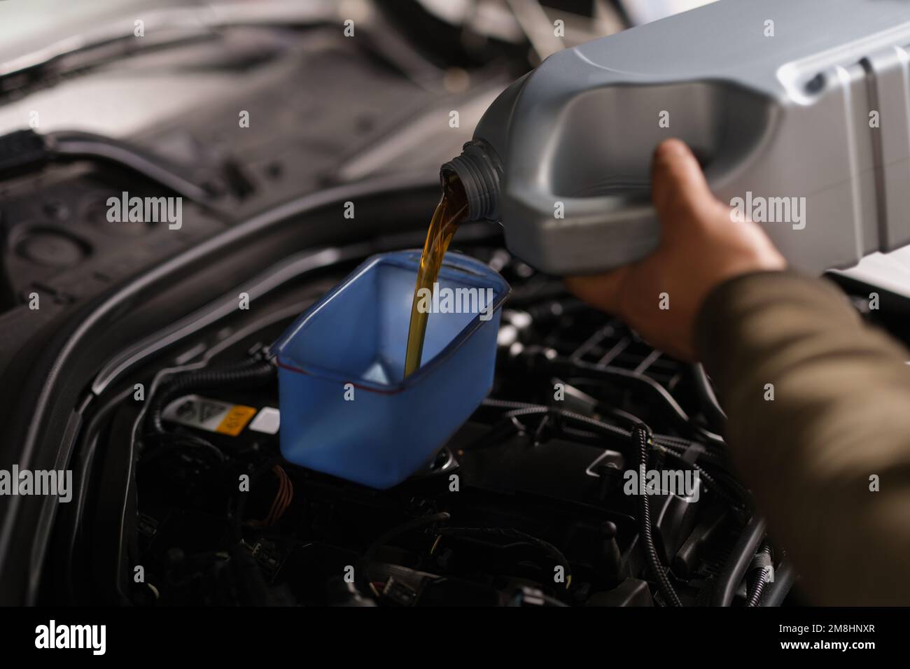 Pouring oil into car engine closeup. Changing oil in engine and gearbox