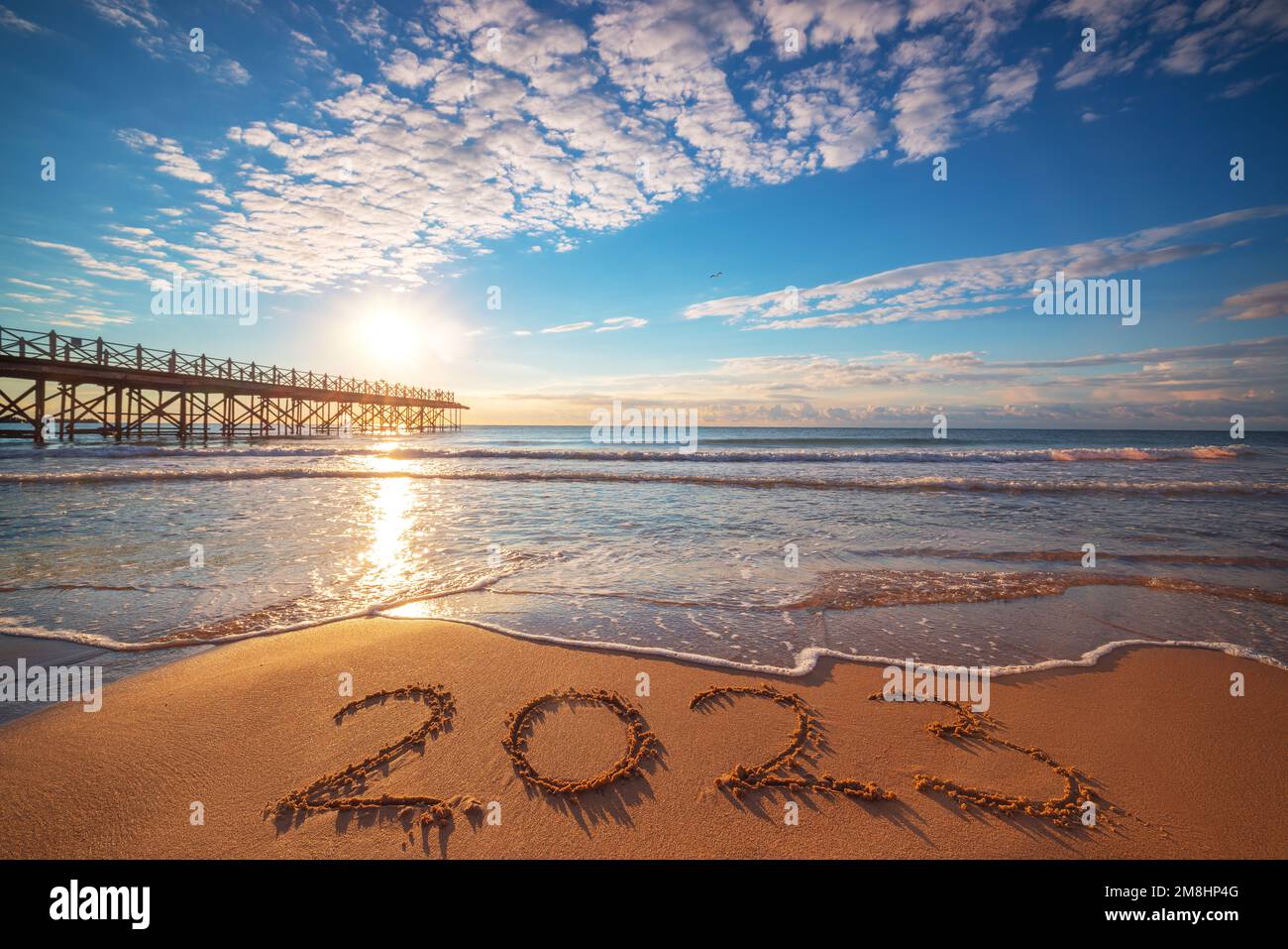 New Year 2023 beach sunrise. Text 2023 in sea sand, nature ocean landscape Stock Photo