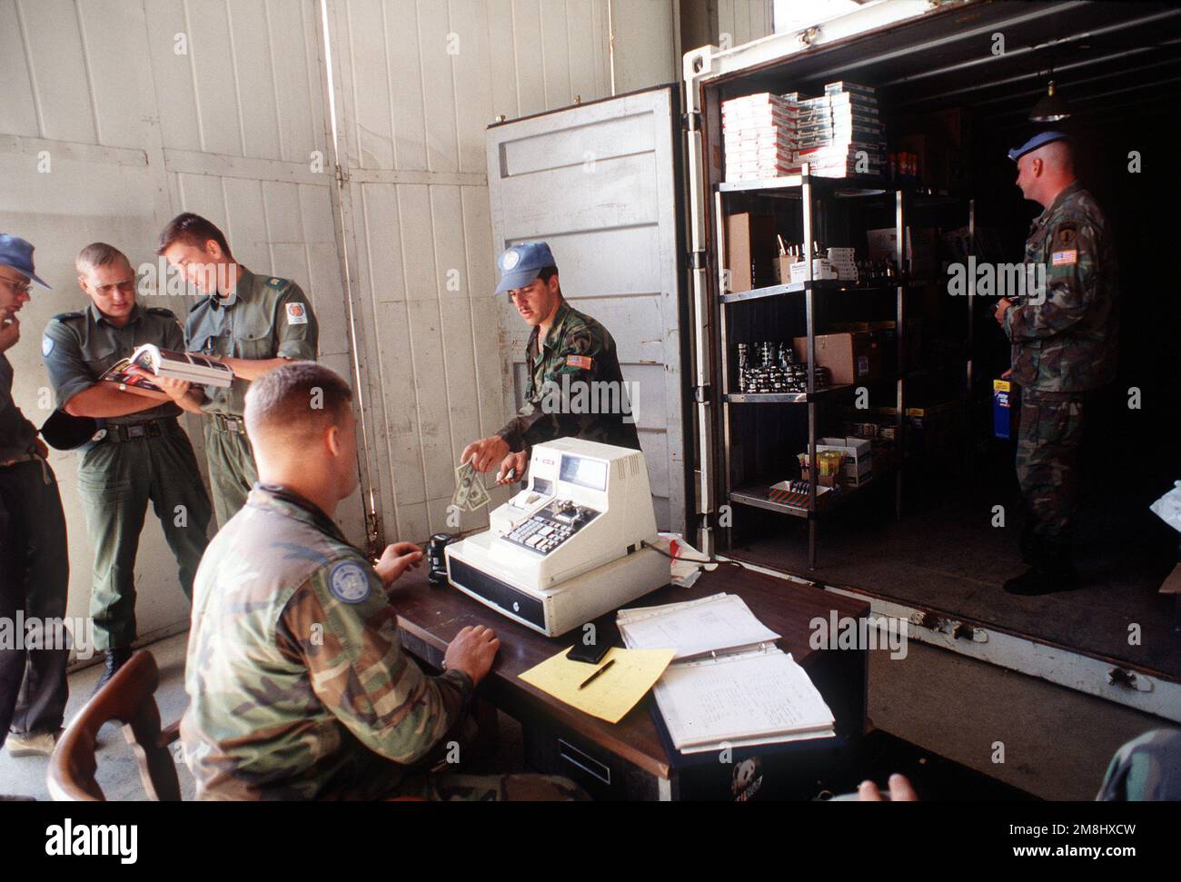 Three soldiers from Finland look at the Post Exchange Catalog. The