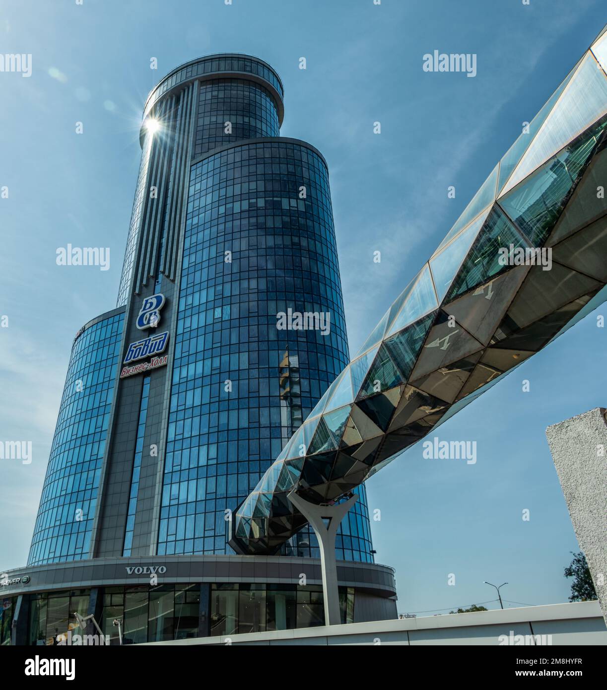 Chelyabinsk, Russia -July 24, 2022. A high-rise building with an overpass entering it against the background of the sky. The inscription on the wall o Stock Photo