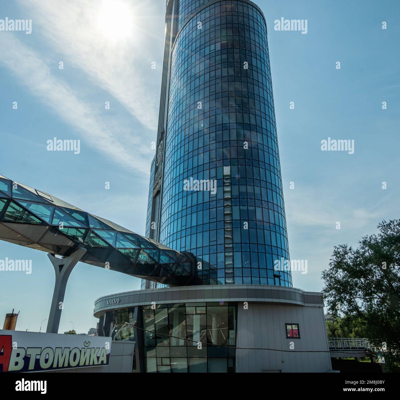 Chelyabinsk, Russia -July 24, 2022. A high-rise building with an overpass entering it against the background of the sky. Stock Photo