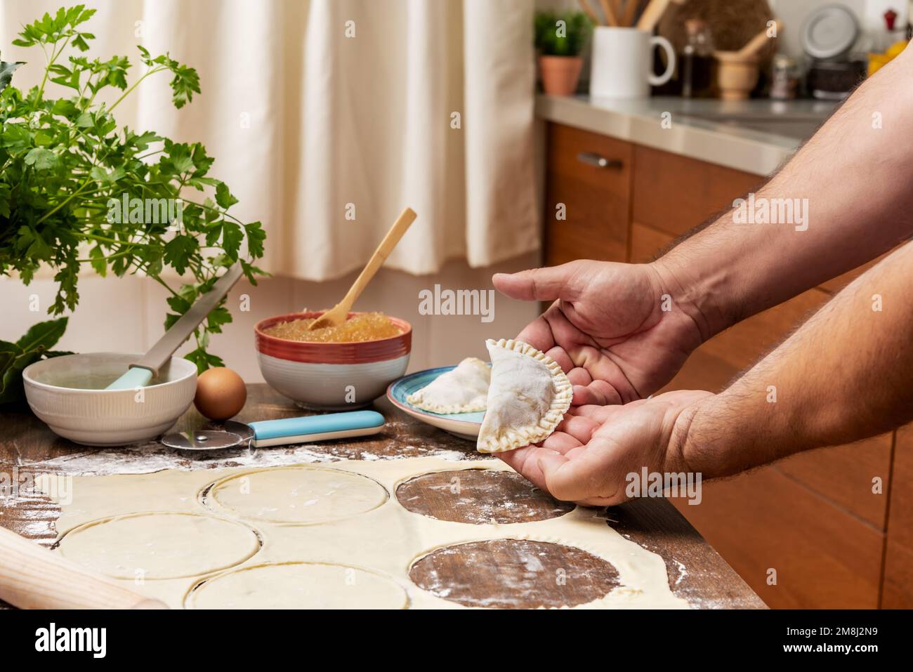 Man's hands with the prepared puff pastry and angel hair. Stock Photo