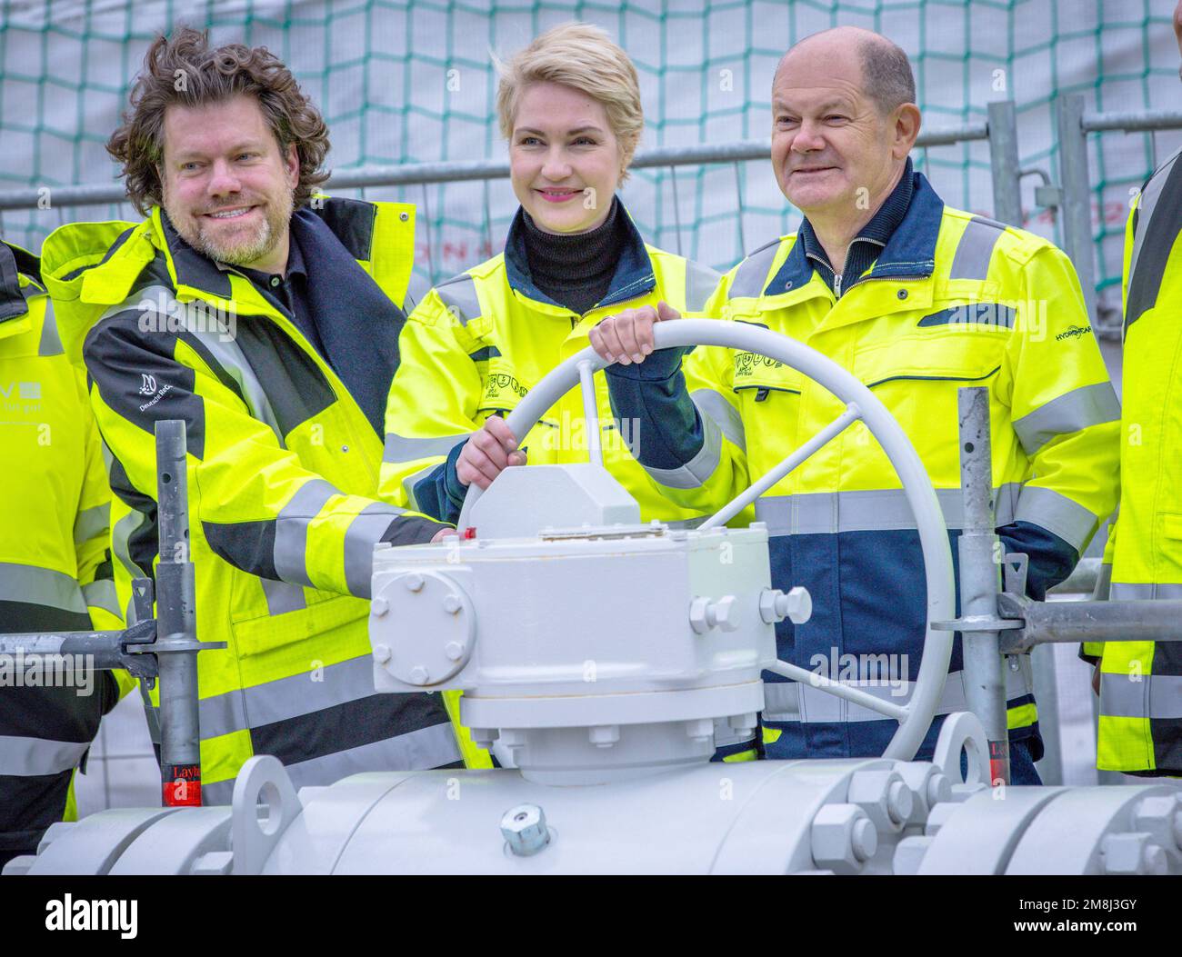 14 January 2023, Mecklenburg-Western Pomerania, Lubmin: German Chancellor Olaf Scholz (SPD, r), Ingo Wagner (l), Managing Director of Deutsche ReGas, and Manuela Schwesig (SPD), the Minister President of Mecklenburg-Western Pomerania, turn a barrier wheel at the LNG terminal with the processing ship 'Neptune', symbolically opening the facility. The terminal for the delivery of liquefied natural gas (LNG), located on the Baltic Sea, is officially commissioned and receives the last outstanding operating permit. Germany is relying on LNG delivered by ship, among other sources, to replace missing  Stock Photo