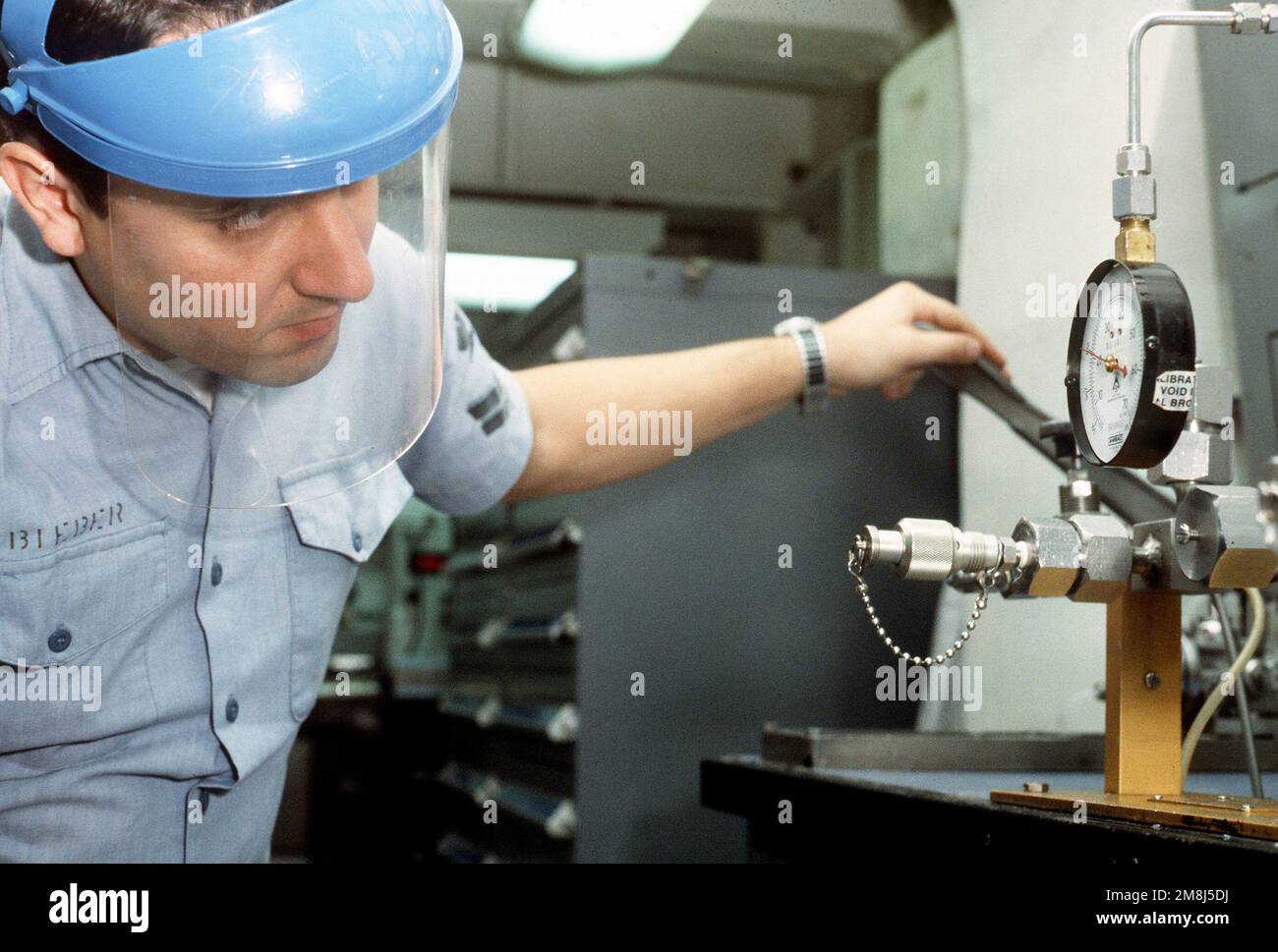 Instrumentman Second Class (IM2) Thomas Bieber calibrates a 1000 PSI