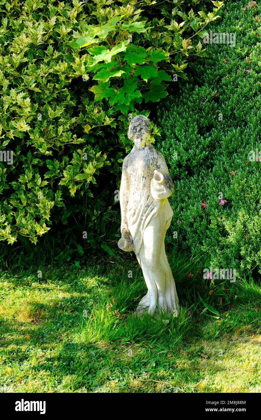 Small classical sculpture in a domestic garden, UK - John Gollop Stock Photo